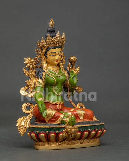 Side view of Green Tara statue seated on a hand carved lotus pedestal.