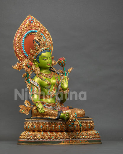 Side view of Green Tara statue seated on lotus throne with utpala flower and halo, handmade in Nepal