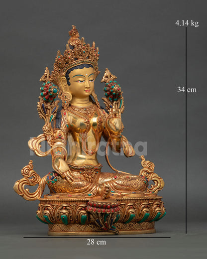 Side view of Green Tara statue seated on blooming lotus pedestal with extended right leg resting on lotus flower representing swift action