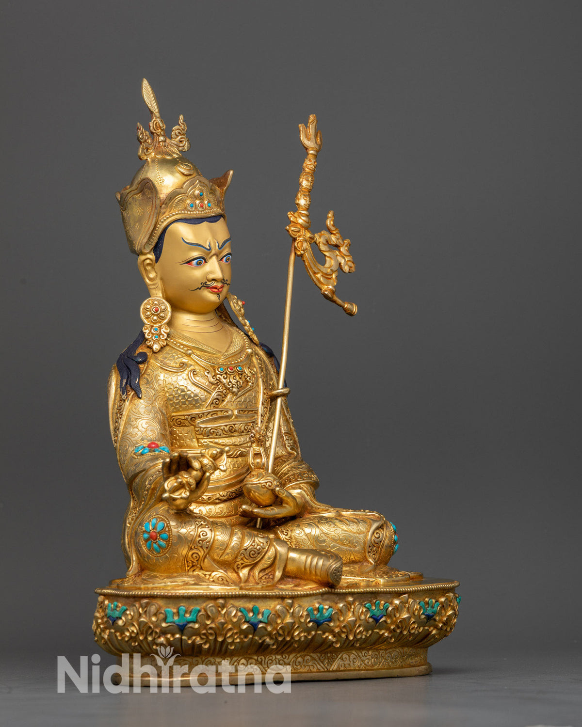 Side view of Guru Padmasambhava statue featuring intricate 3D carvings, vajra, kapala, and sacred khatvanga staff