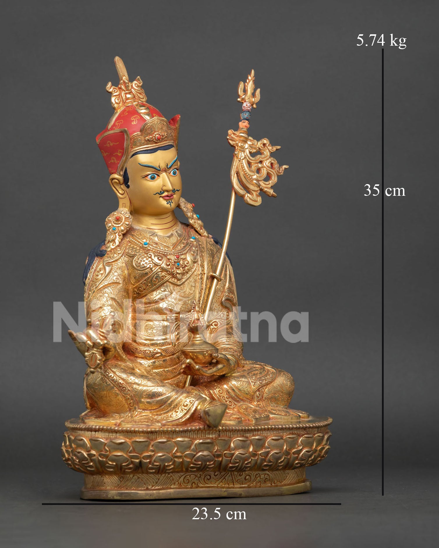 Side view of Guru Rinpoche Buddhist statue, featuring engraved robes vajra skull cup and Khatvanga trident