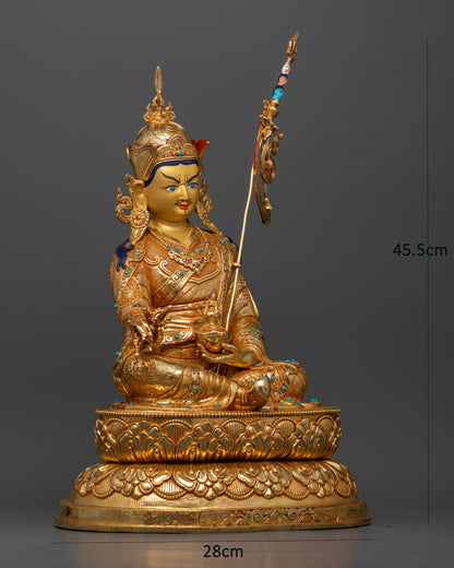 Side view of Guru Rinpoche Padmasambhava statue with vajra, skull cup and intricate floral royal garments.