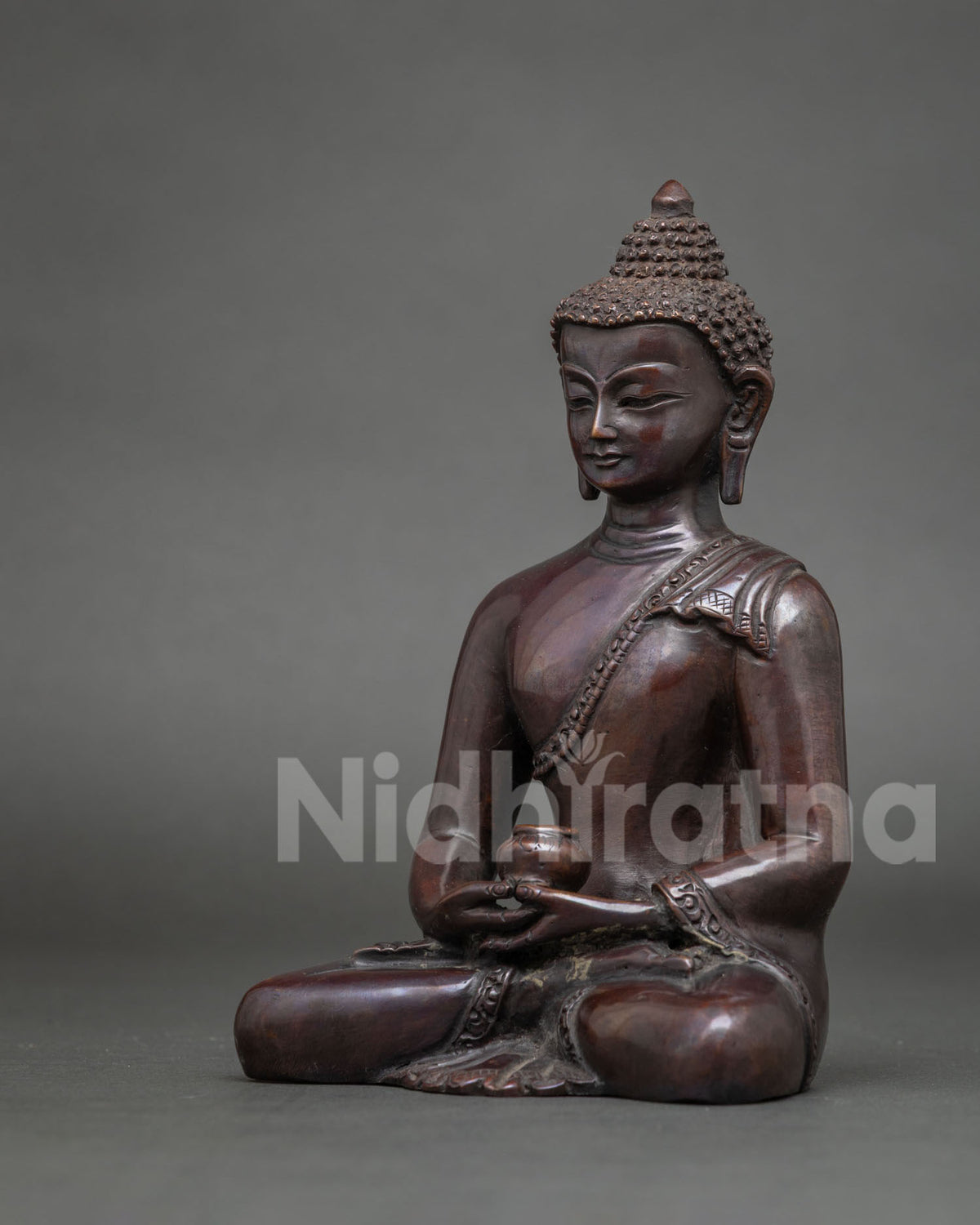 Side view of handmade Amitabha Buddha statue showing seated meditation pose and copper patina