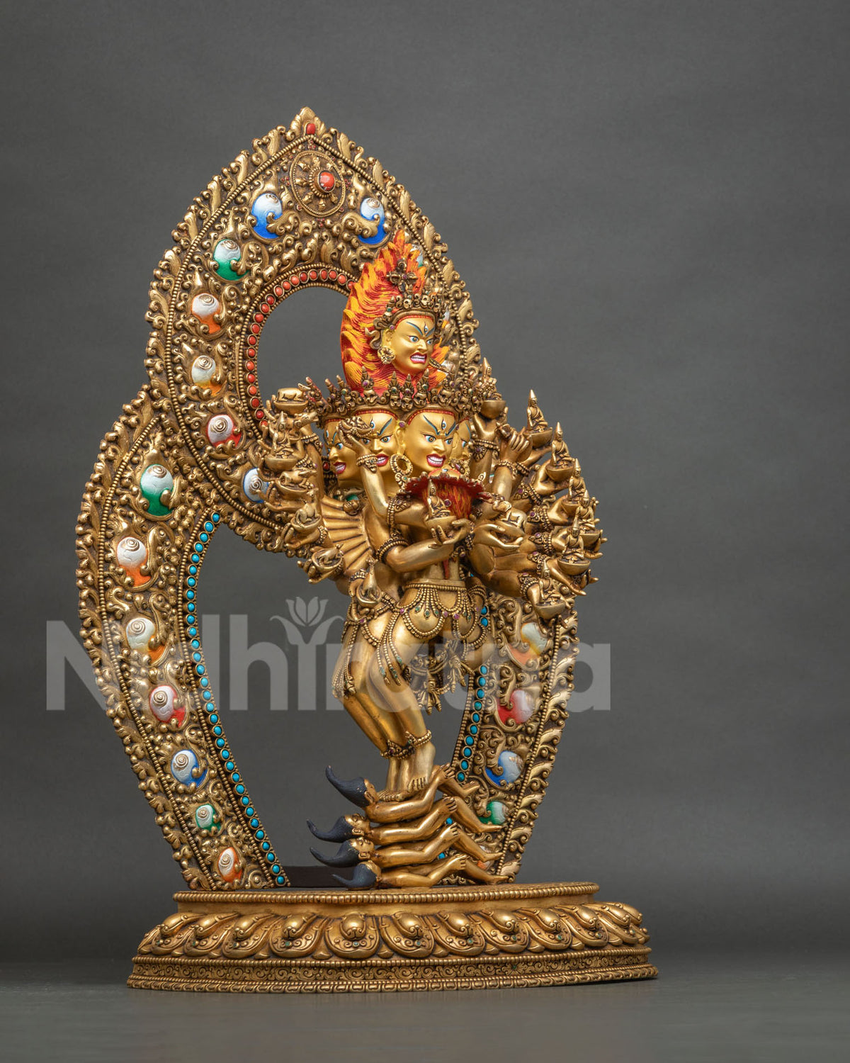 Side view of Hevajra Yab-Yum statue showing sixteen arms, floral halo and lotus base, Nepal