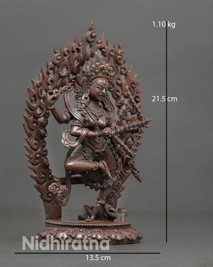 Side view of Himalayan Kurukulla sculpture in dynamic posture with flames and lotus throne in oxidized metal finish