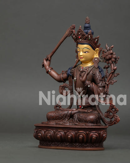 Side view of Manjushri Bodhisattva statue holding Prajnaparamita flower and flaming wisdom sword.