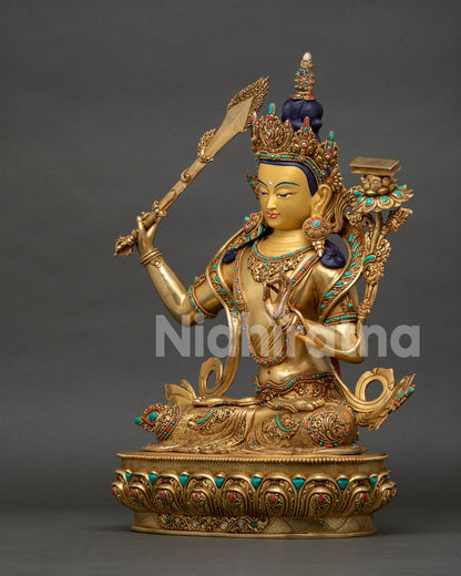 Side view of Manjushri Statue displaying lotus pedestal and detailed repoussé metalwork