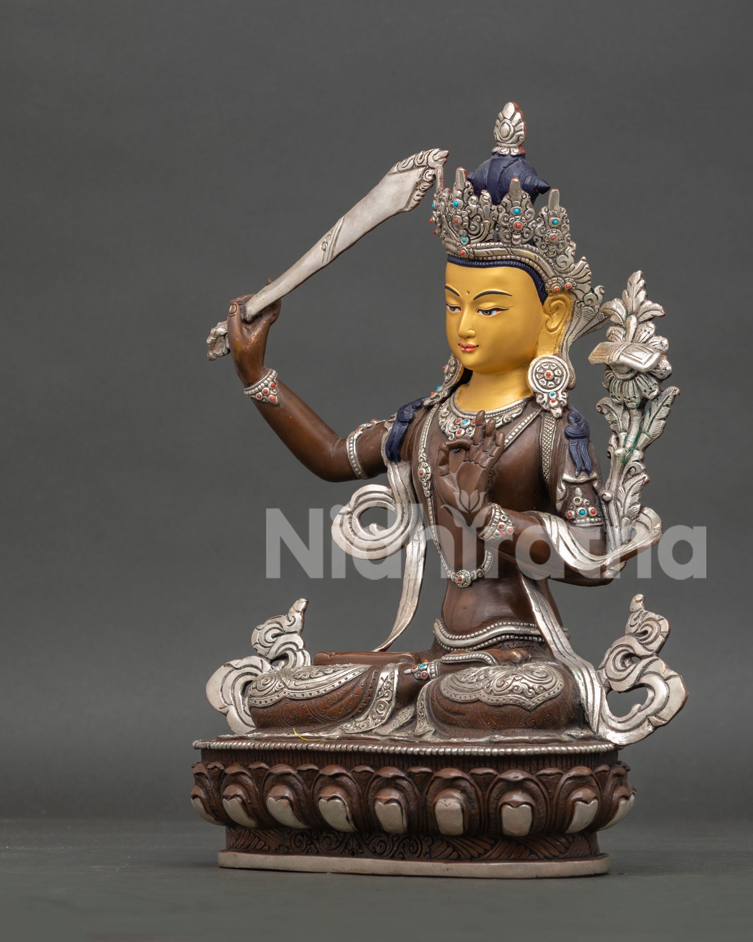 Side view of Manjushri statue, featuring Prajnaparamita scripture, lotus flower and traditional Himalayan craftsmanship