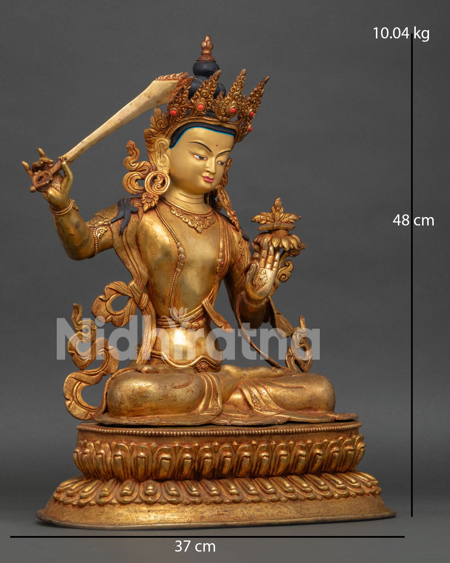 Side view of Manjushri statue showing copper craftsmanship, semi precious stones, and sacred Buddhist details