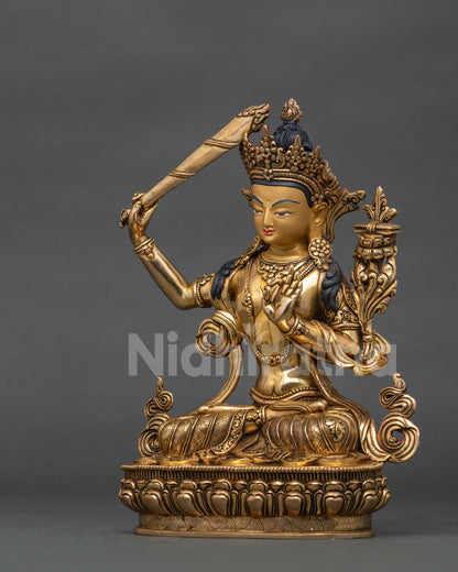 Side view of manjushri statue with hand carved lotus pedestal and floral silk garment.
