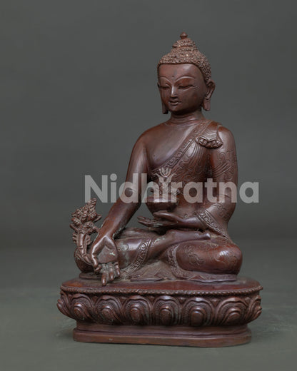 Side view of Medicine Buddha Statue with oxidized copper finish and lotus pedestal details.