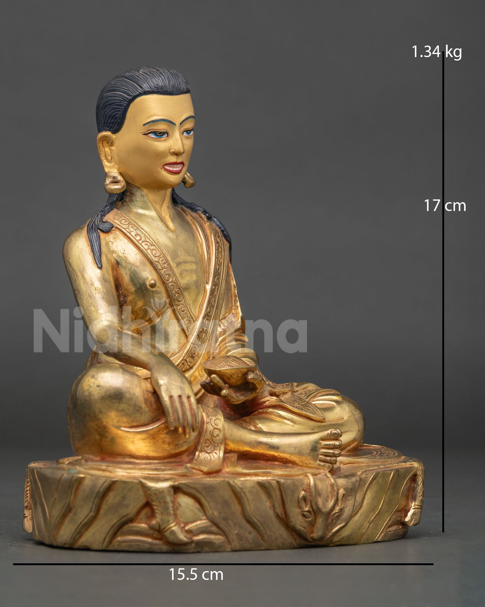 Side view of Milarepa, Tibetan saint statue, seated in meditative ease posture with right hand resting on knee and detailed lotus base carving