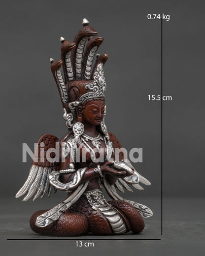 Side view of Naga Kanya statue, holding a conch shell with flowing robes and celestial wings