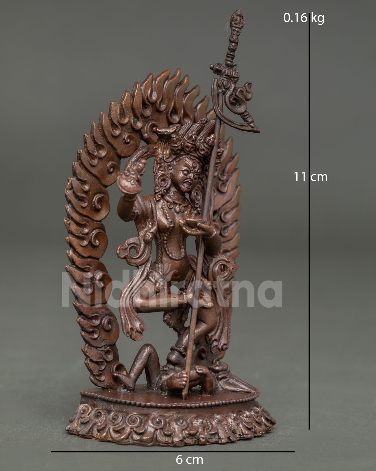 Side view of oxidized copper Dorje Phagmo statue in standing posture with khatvanga staff and flaming aureole