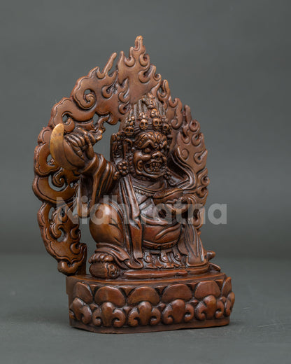 Side view of oxidized copper Tibetan Mahakala Bernagchen statue with kartika knife and skull cup.