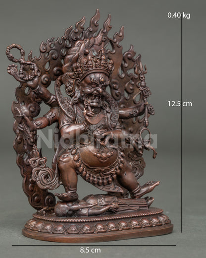 Side view of Shadbhuja Mahakala statue holding damaru trident lasso and skull cup