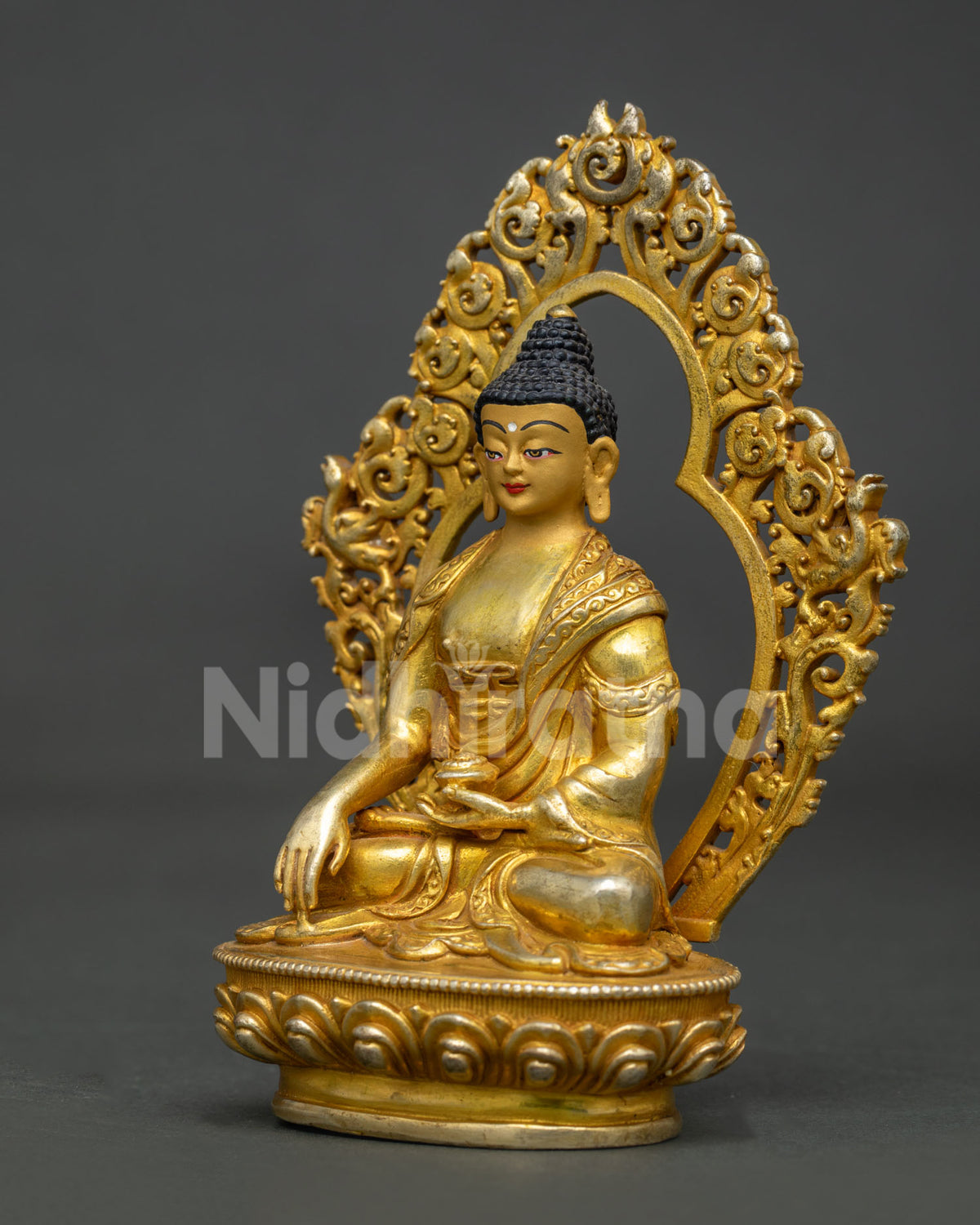 Side view of Shakyamuni Buddha seated on hand carved lotus pedestal.