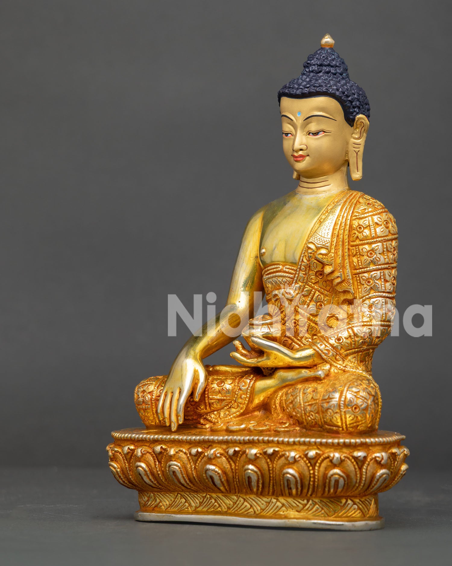 Side view of Shakyamuni Buddha statue in Earth Touching Mudra holding a traditional begging bowl.