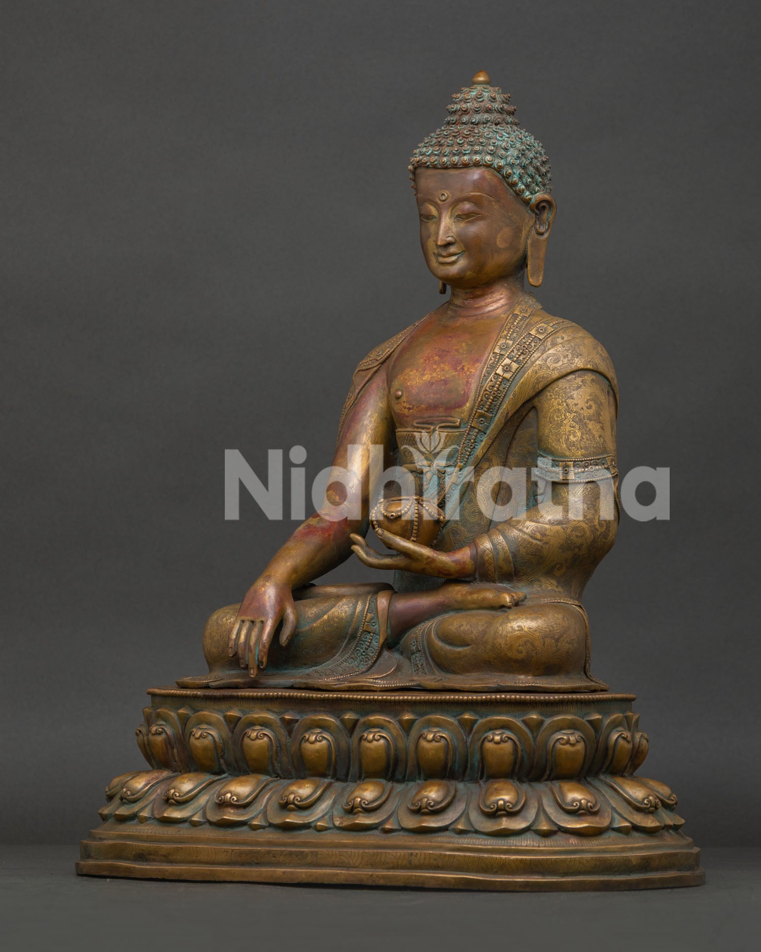 Side view of Shakyamuni Buddha statue showing intricate monk robe and double lotus pedestal.