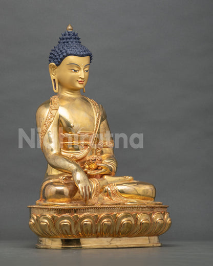 Side view of Shakyamuni Buddha statue with Earth Touching Mudra and alms bowl on a lotus pedestal
