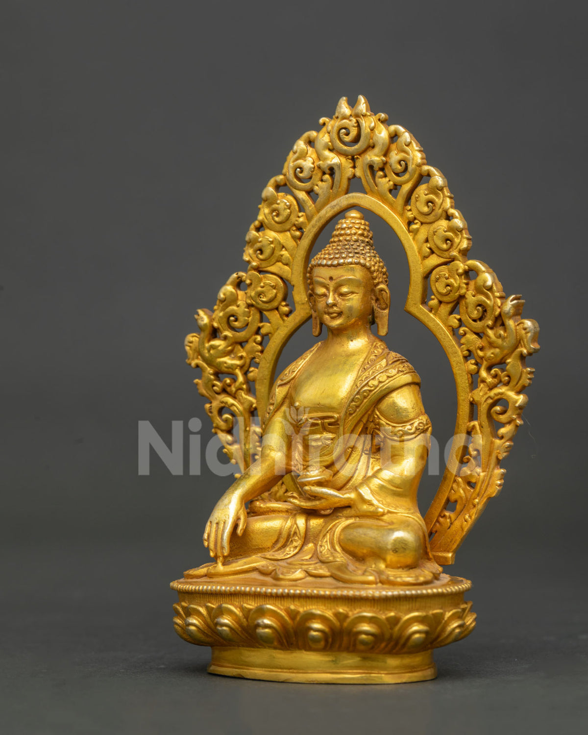 Side view of Shakyamuni Buddha statue with gold fire gilded finish and ornate halo.