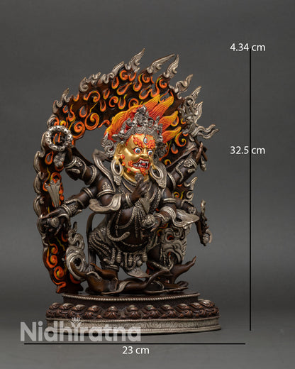 Side view of Six-Armed Mahakala statue holding sacred implements, standing on lotus base with flame halo, Dharma protector sculpture