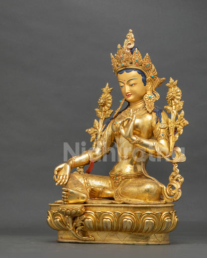 Side view of the seated Green Tara copper statue in Varada Mudra with right leg extended on a lotus throne
