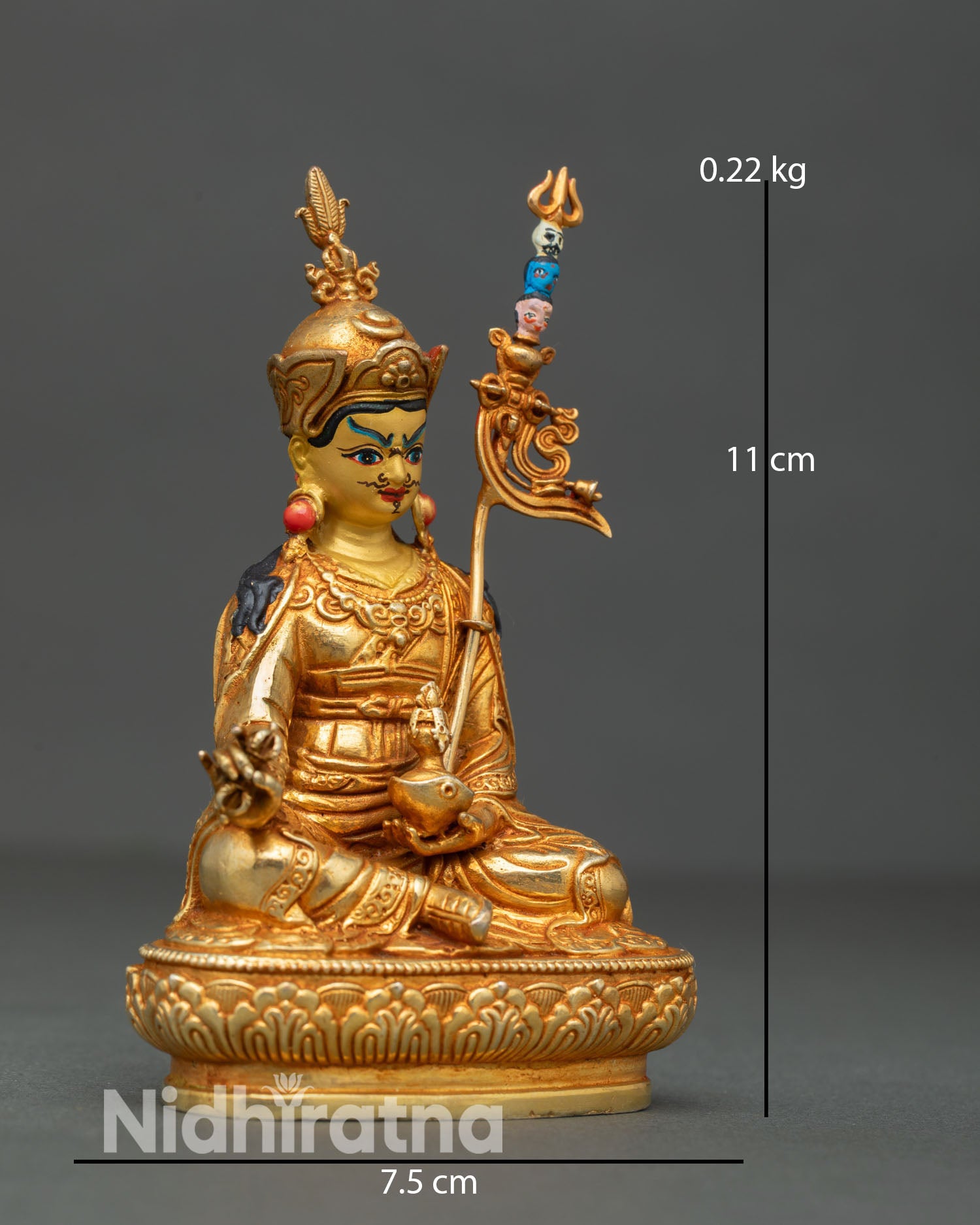 Side view of Tibetan Guru Rinpoche sculpture depicting khatvanga trident staff flowing robes and majestic seated posture on carved lotus throne