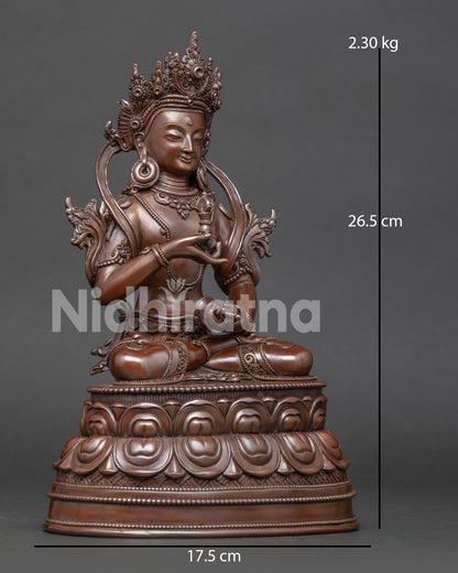 Side view of Vajrasattva Buddhist sculpture holding the vajra and bell