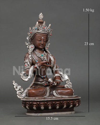 Side view of Vajrasattva statue depicting vajra in right hand bell in left hand and traditional Tibetan Buddhist symbolism