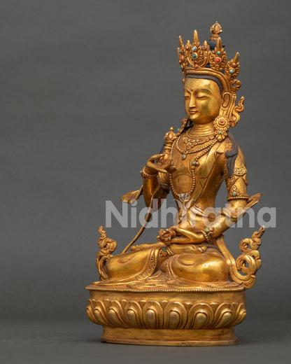 Side view of Vajrasattva Statue with flowing robes lotus pedestal and sacred ornaments Nepal.