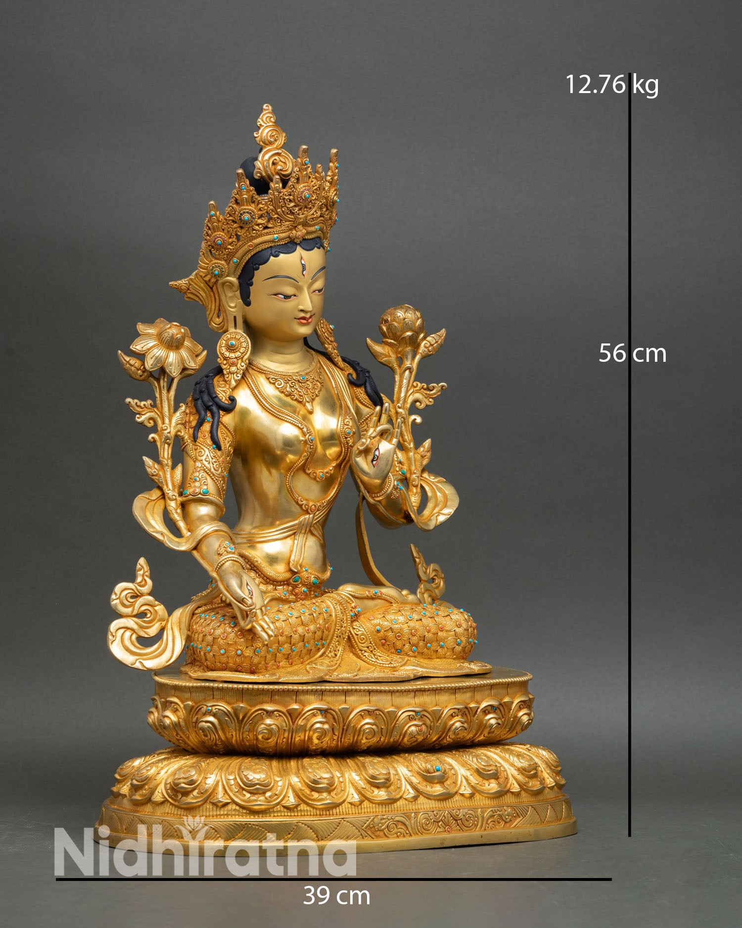 Side view of White Tara statue seated on double lotus pedestal lost wax copper casting with sacred Buddhist iconography and gold gilded finish