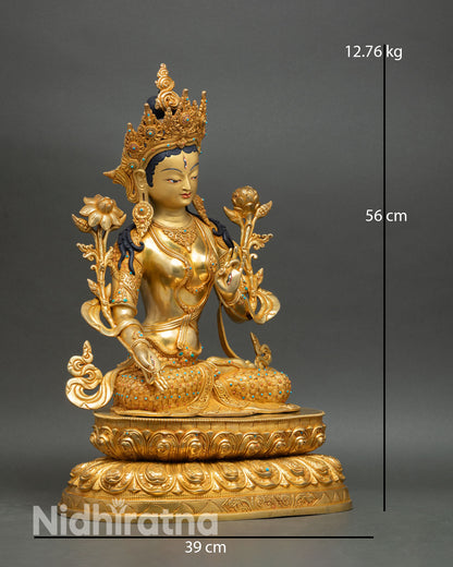 Side view of White Tara statue seated on double lotus pedestal lost wax copper casting with sacred Buddhist iconography and gold gilded finish