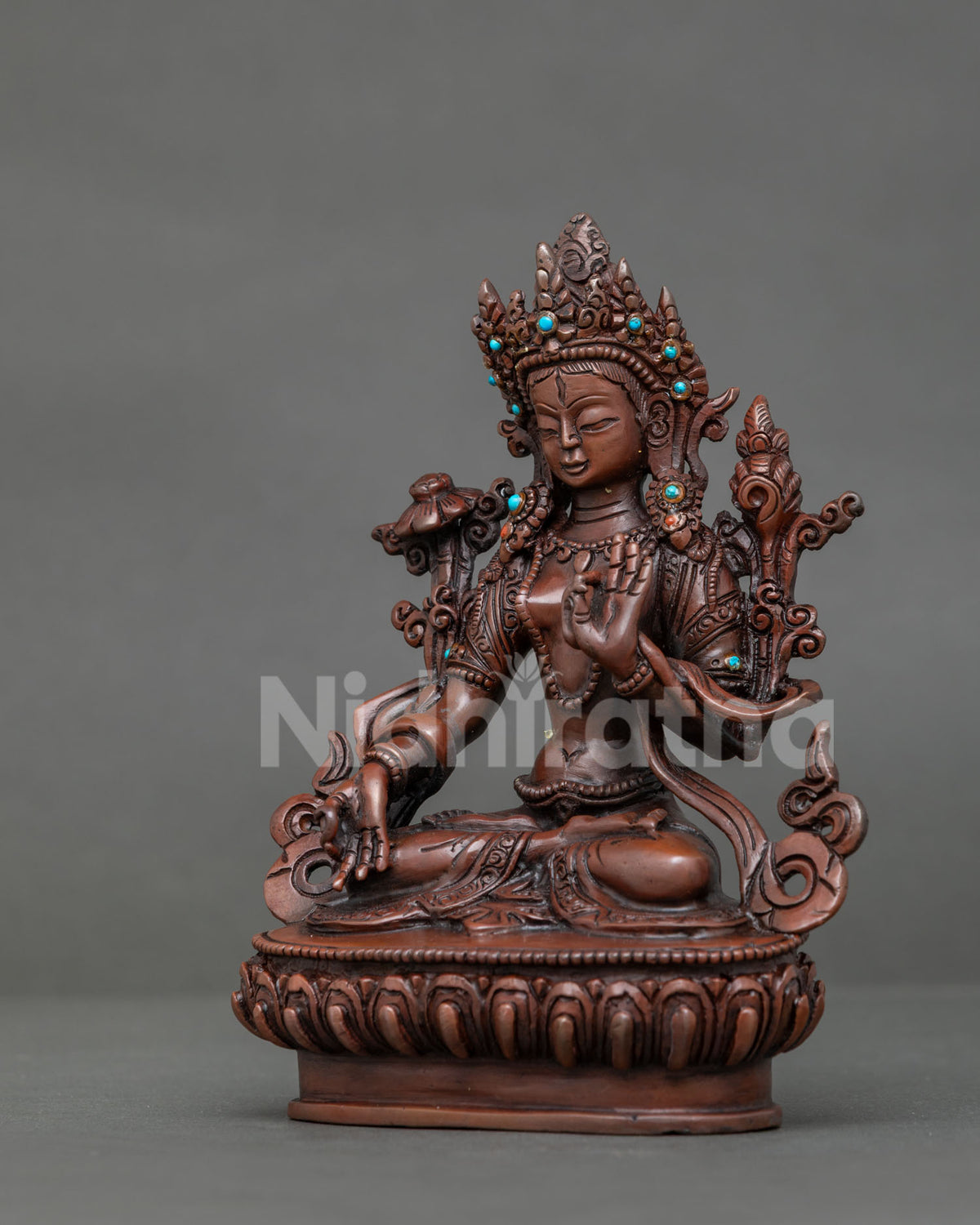Side view of white tara statue with oxidized copper finish and detailed lotus pedestal.