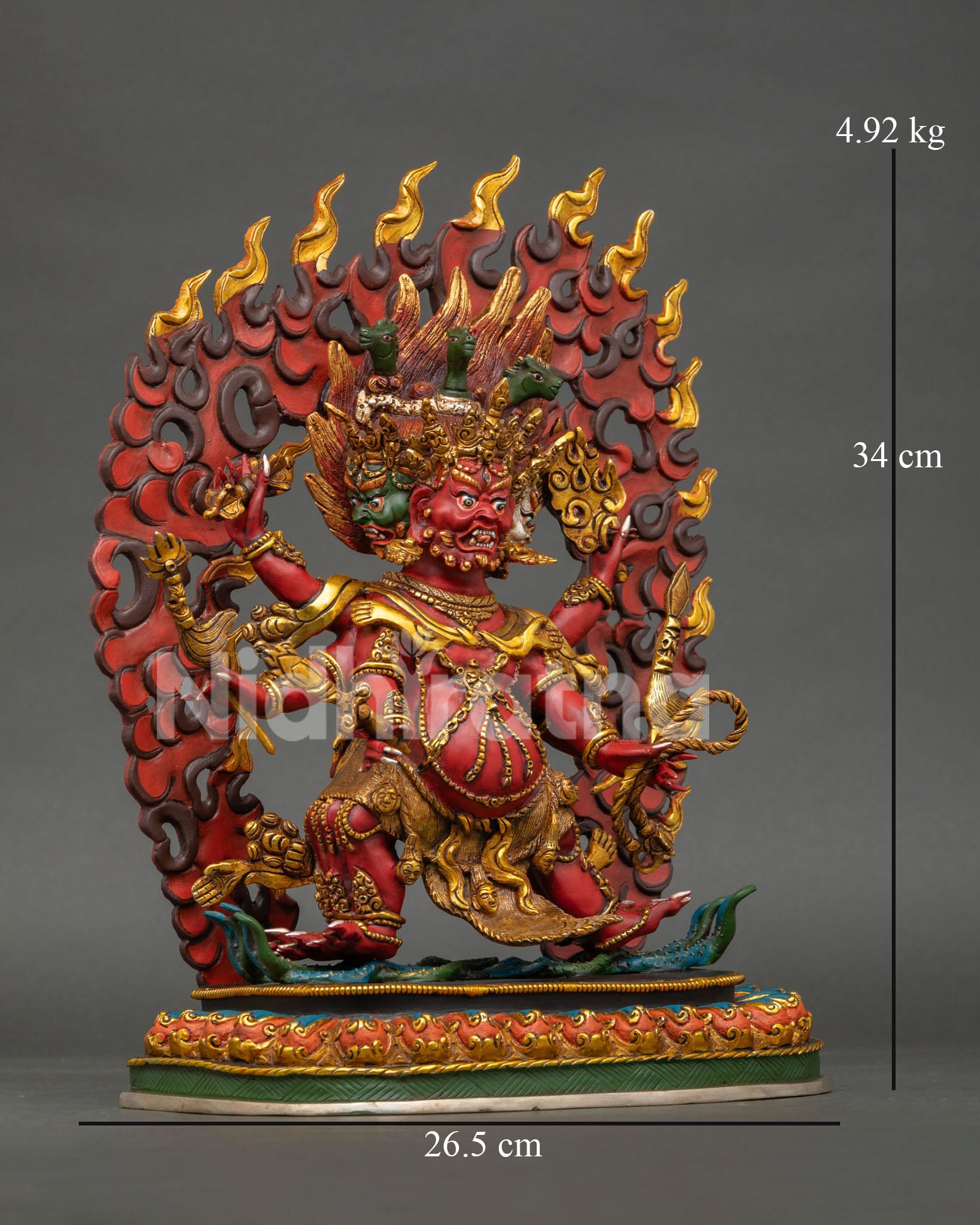 Side view of wrathful Hayagriva sculpture displaying sacred ritual objects, lotus throne, and vibrant acrylic painted details.