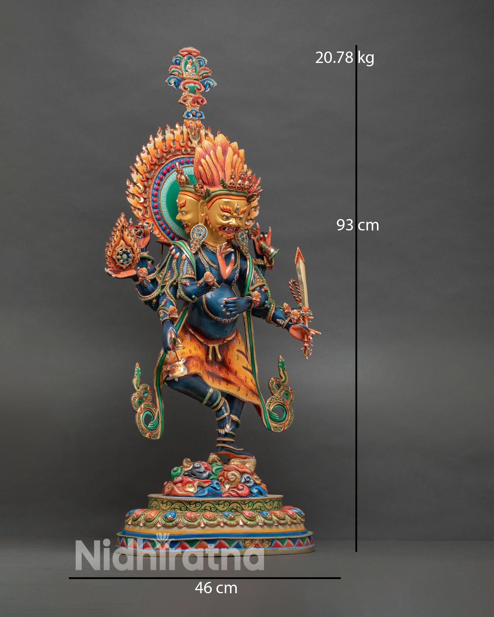 Side view of wrathful Ucchusma deity statue with multiple arms holding ritual objects, tiger skin garment, and flaming halo with miniature Buddha