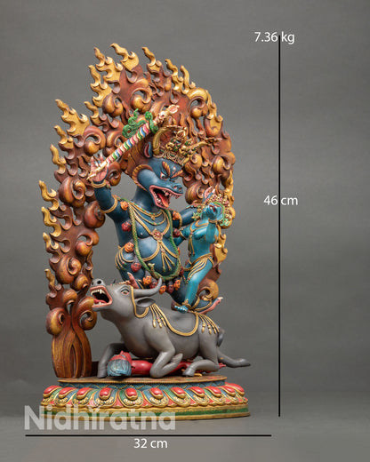 Side view of wrathful Yamantaka union statue standing on buffalo and lotus base symbolizing victory over ego, ignorance, and death in Vajrayana Buddhism