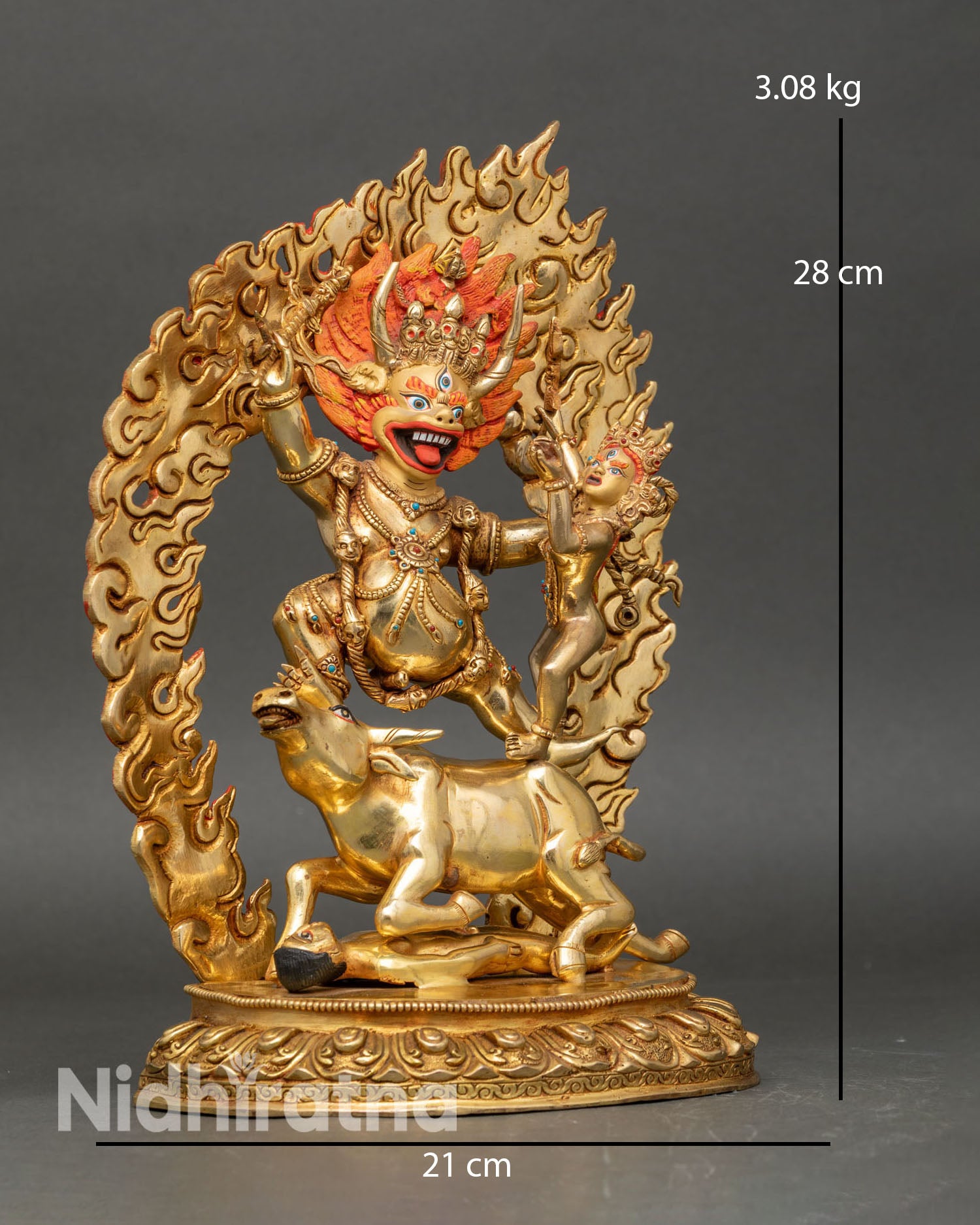 Side view of Yamantaka statue standing atop a buffalo with fiery halo and detailed carvings.