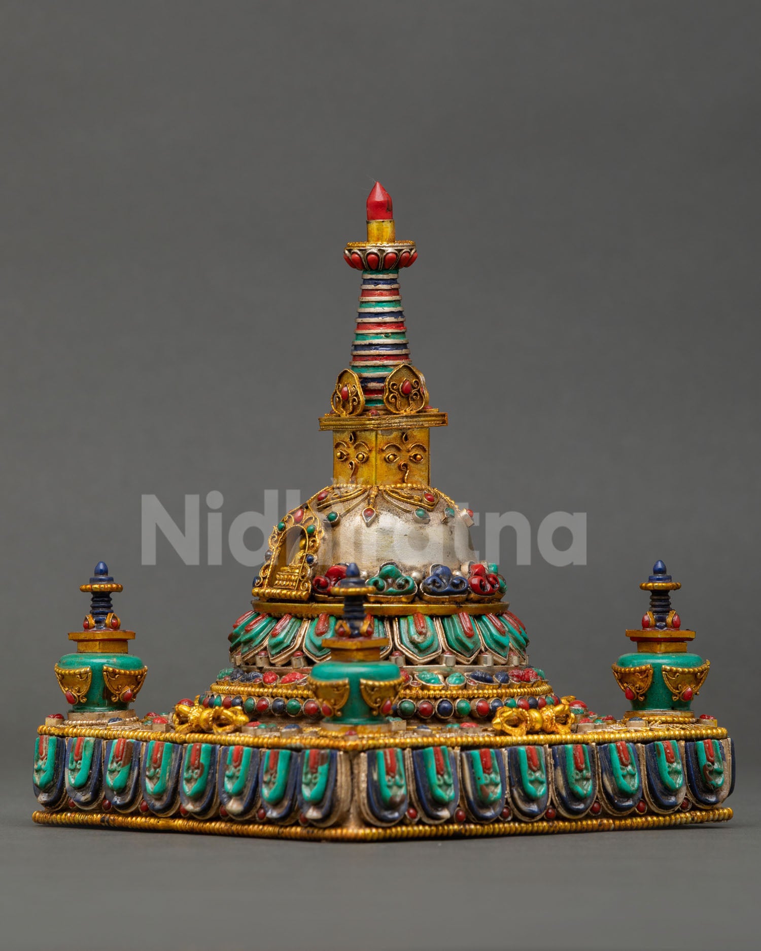 Side view pf ornate Tibetan Buddhist Stupa with tiered lotus base dome harmika and thirteen ring spire, handcrafted Nepalese spiritual shrine with fine metal detailing