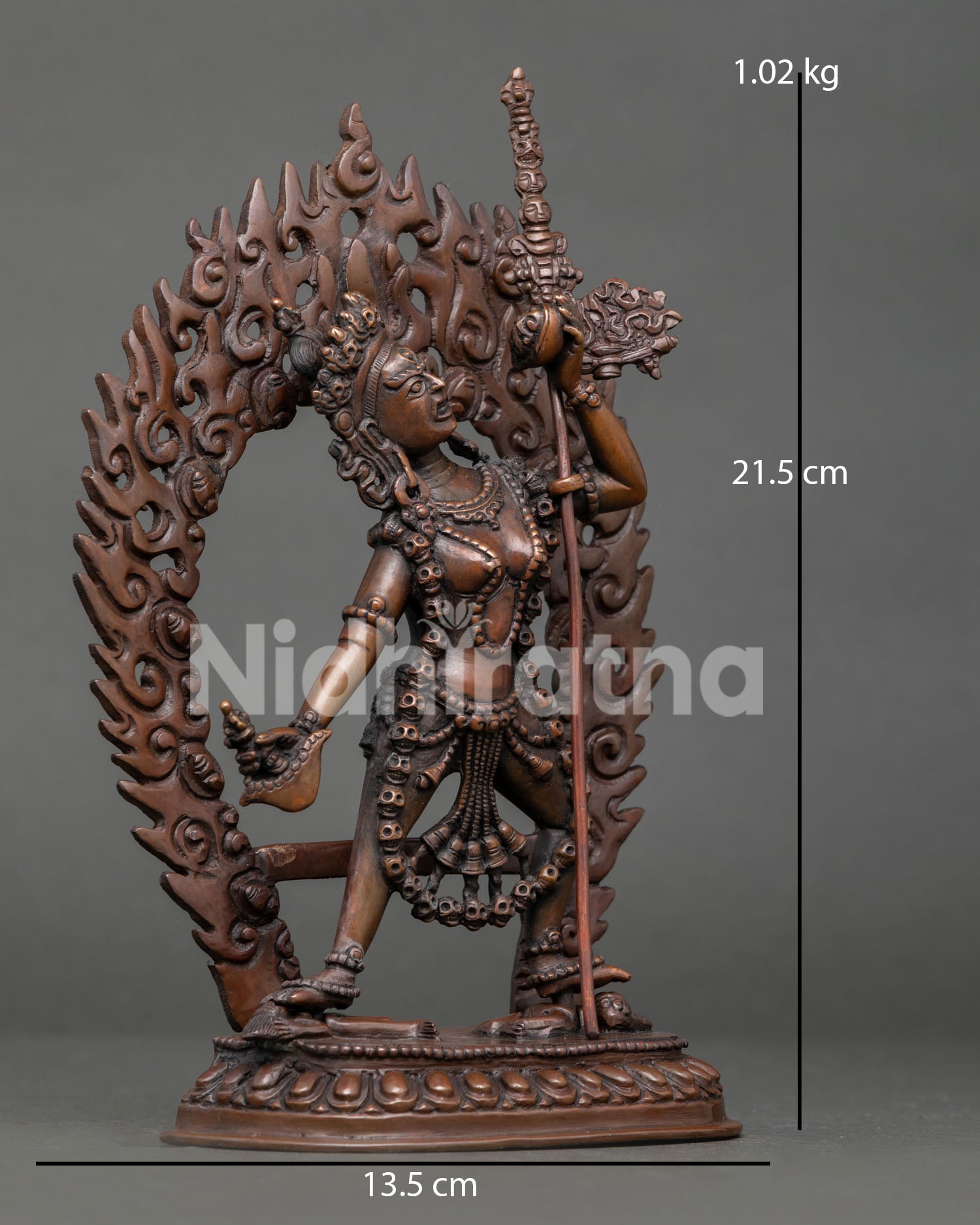 Side view of Vajrayogini statue, standing on subdued figures holding trident in dynamic posture