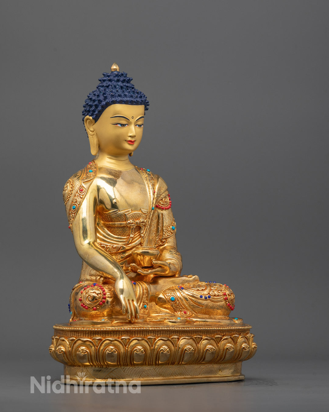 side angle of Shakyamuni Buddha Statue showing carved alms bowl and flowing robe with stones
