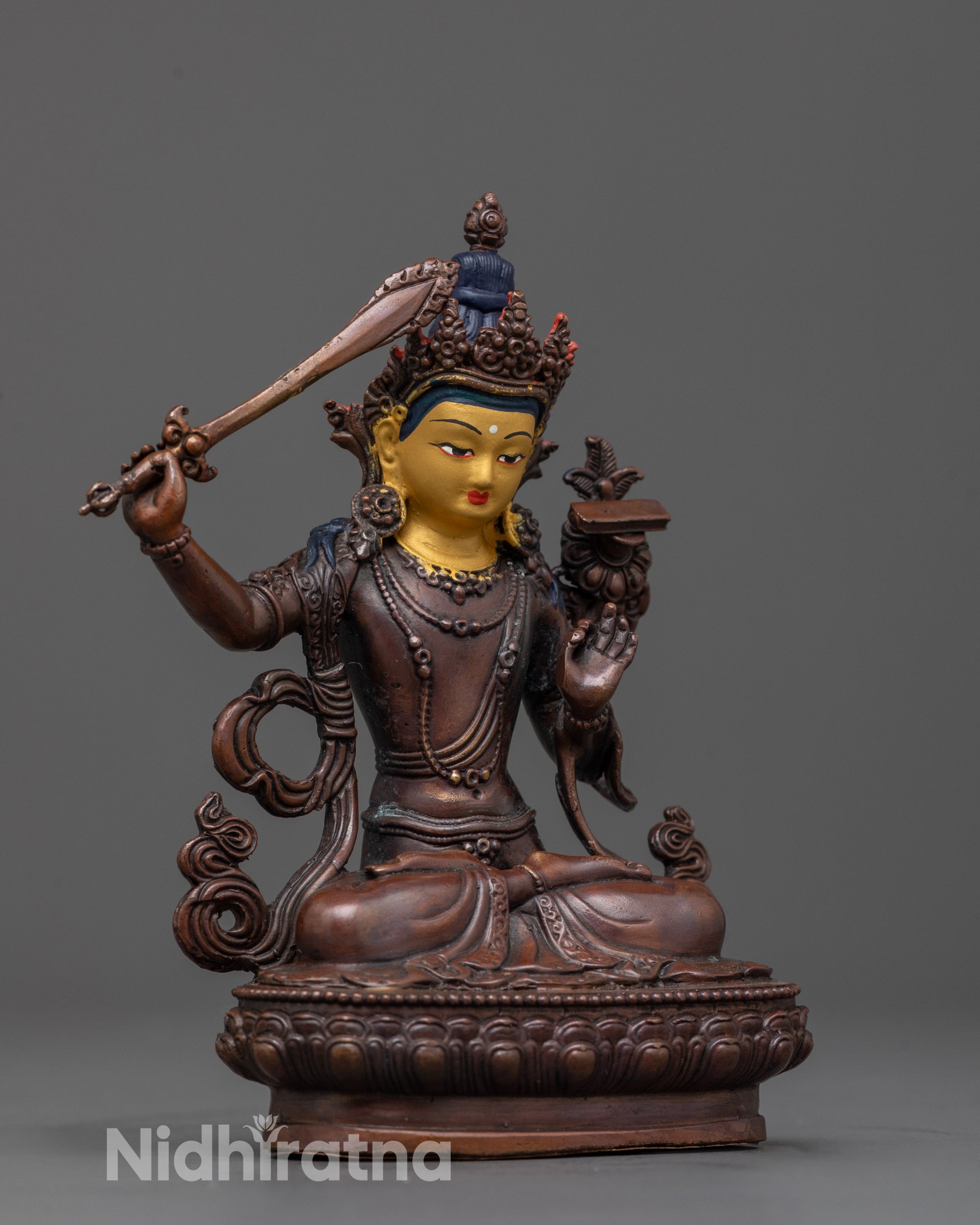 side angle of copper manjushri statue with flowing robes and utpala lotus flower