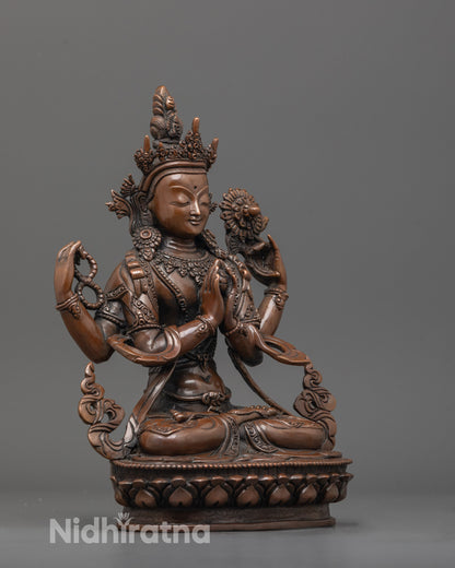 side angle of four-armed chenrezig sculpture holding sacred objects and wish gem