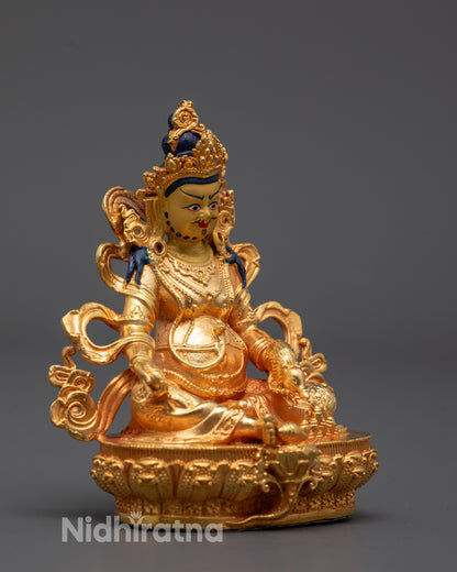 side angle of gold-plated Jambhala statue showing citron fruit and conch shell