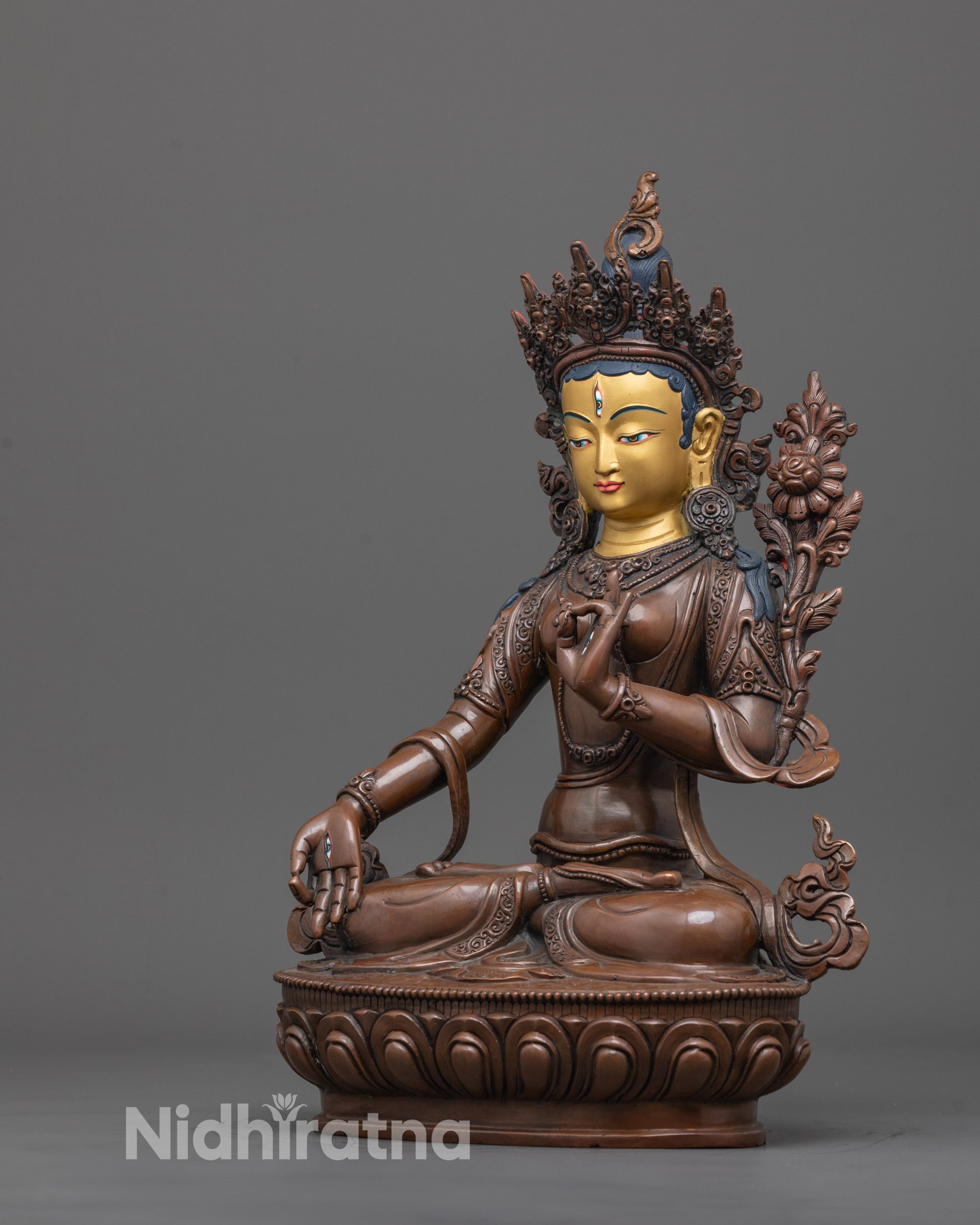 side angle of handcrafted white tara statue showing blessing mudra and serene expression