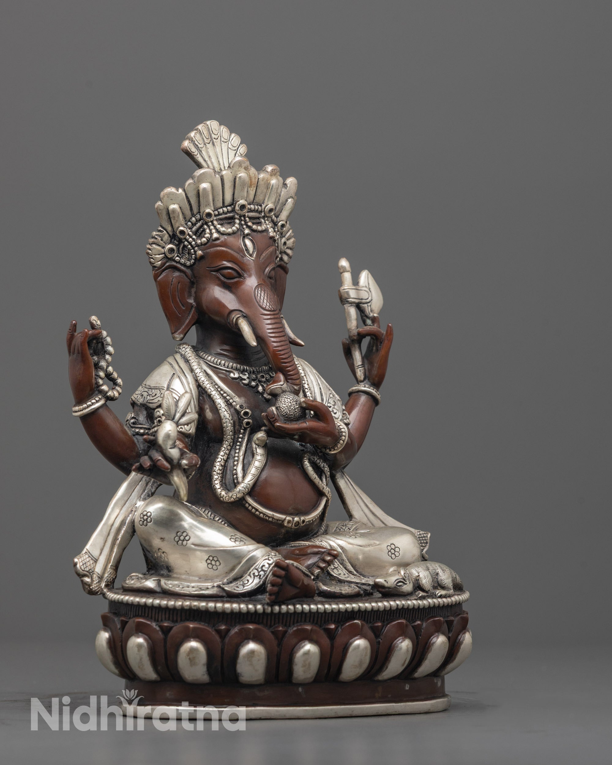 side angle of lord ganesha statue showing sacred items and seated royal ease posture