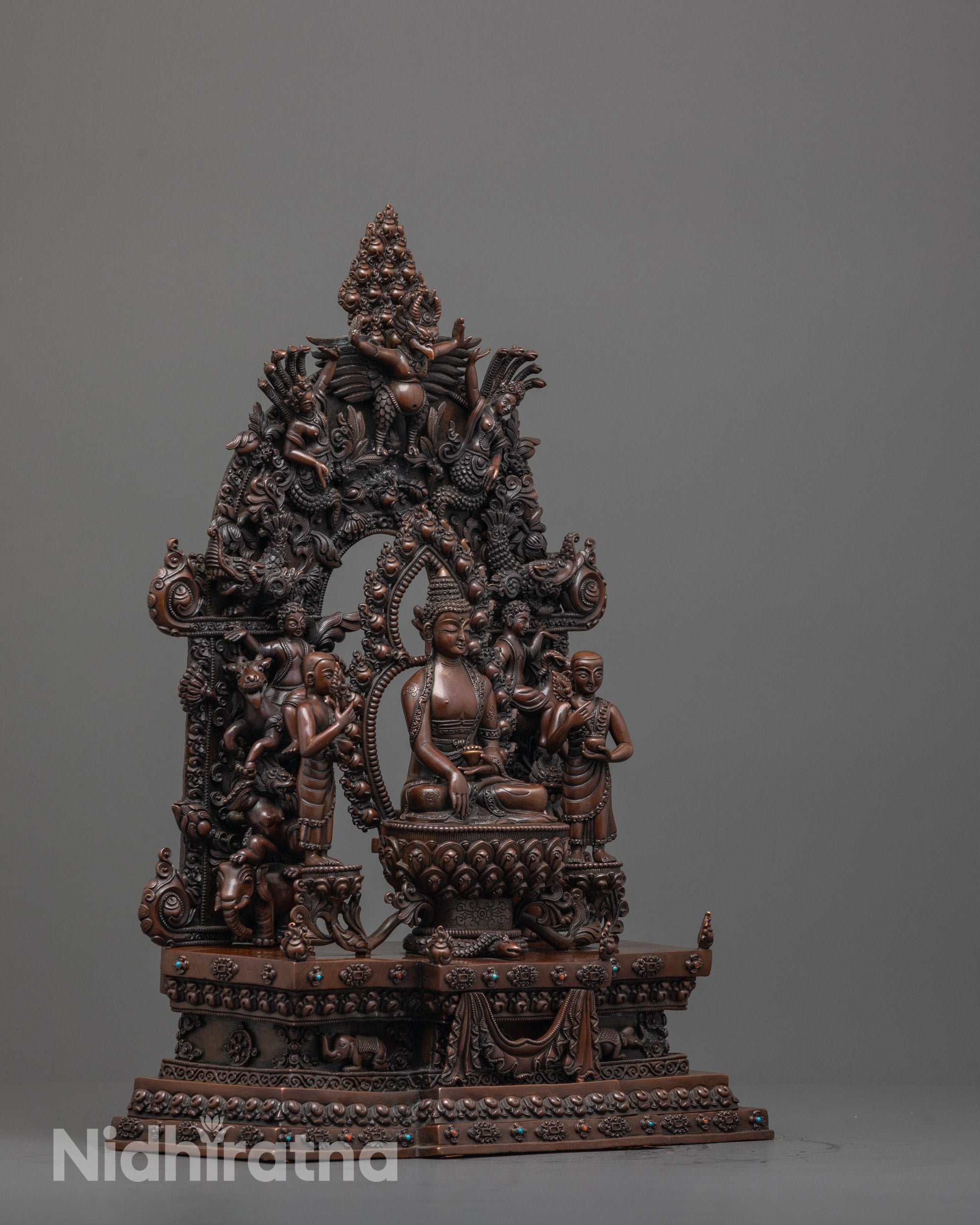side angle of oxidized copper buddha statue showing disciples and detailed handmade halo