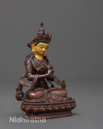 side angle of oxidized vajradhara statue holding vajra and bell
