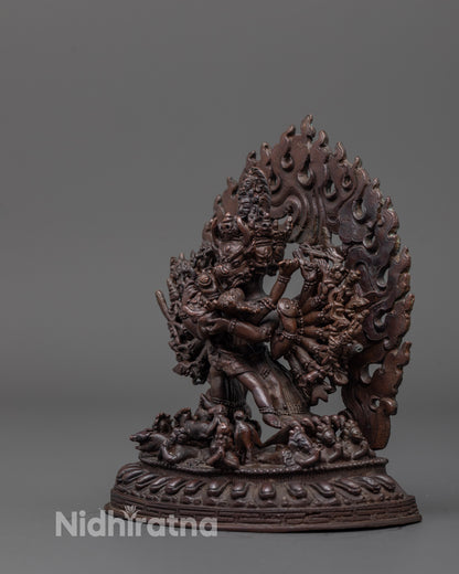 side angle of yamantaka statue with flowing robes and small deity near foot