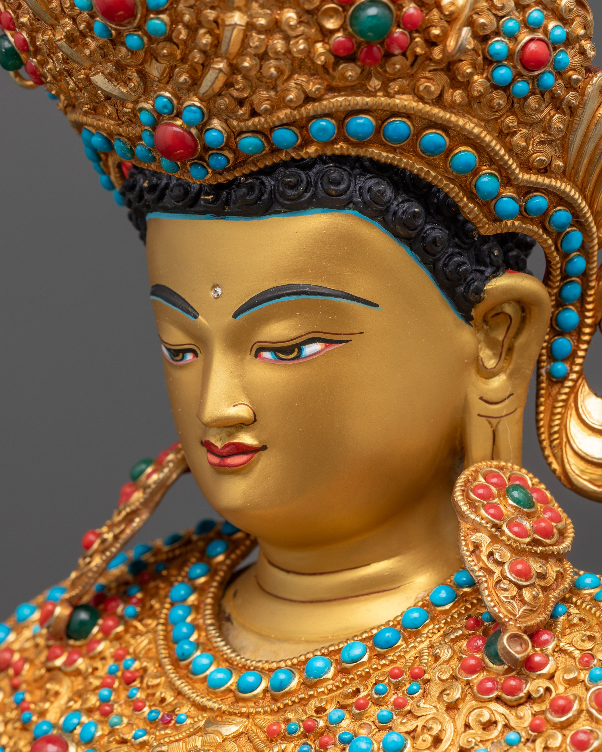 side close up face Jowo Shakyamuni Rinpoche statue with calm gold gilded expression and earrings